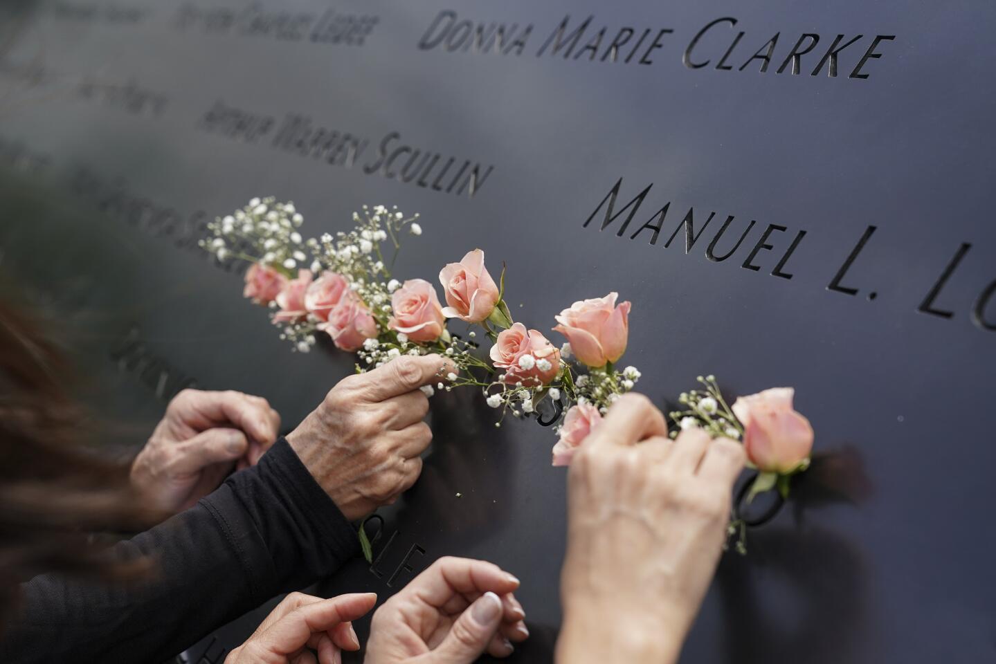 Mourners place flowers in the cut-out name of Kyung Hee "Casey" Cho at the National September 11 Memorial in New York.