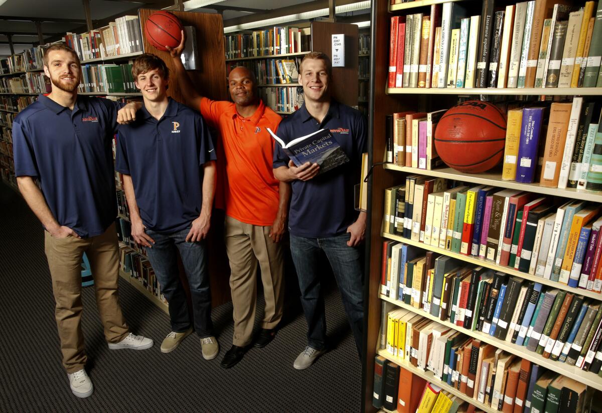 Marty Wilson, Pepperdine men's basketball coach, stands next to players (left to right) Brendan Lane, Jett Raine and Malte Kramer in the university's library. Pepperdine's renewed focus on academics has helped members of its basketball team excel in the classroom.