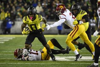 Oregon running back Bucky Irving (0) gets past Southern California linebacker Mason Cobb (13) and defensive end Romello Height (2) during the second half of an NCAA college football game Saturday, Nov. 11, 2023, in Eugene, Ore. (AP Photo/Andy Nelson)