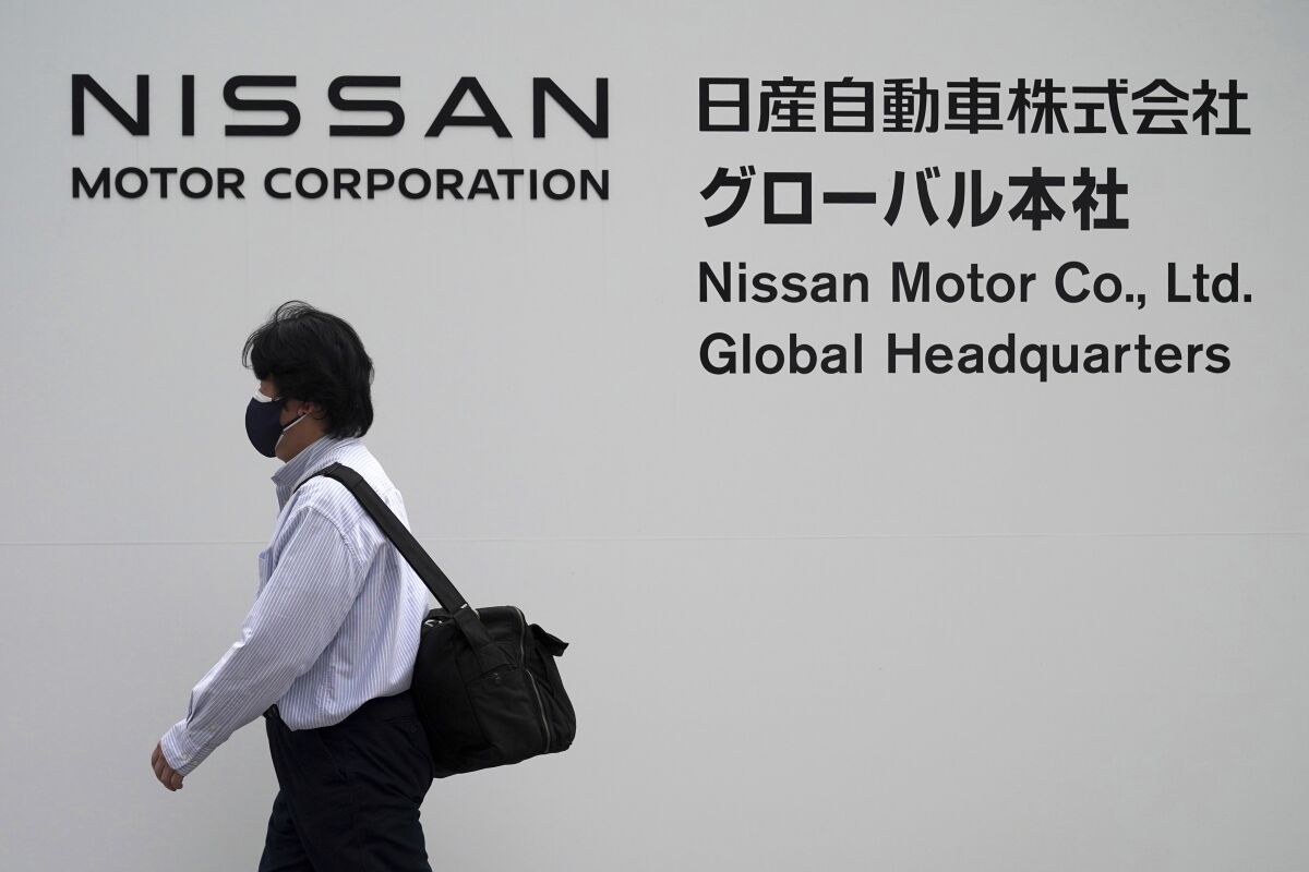 A man walks in front of Nissan headquarters Thursday, May 12, 2022, in Yokohama near Tokyo. Japanese automaker Nissan returned to profitability in the last fiscal year for the first time in three years, despite challenges such as supply shortages caused by the pandemic and soaring costs. (AP Photo/Eugene Hoshiko)