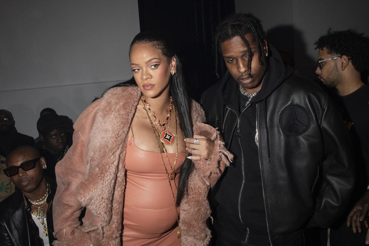 A stylish woman and man pose at a fashion show