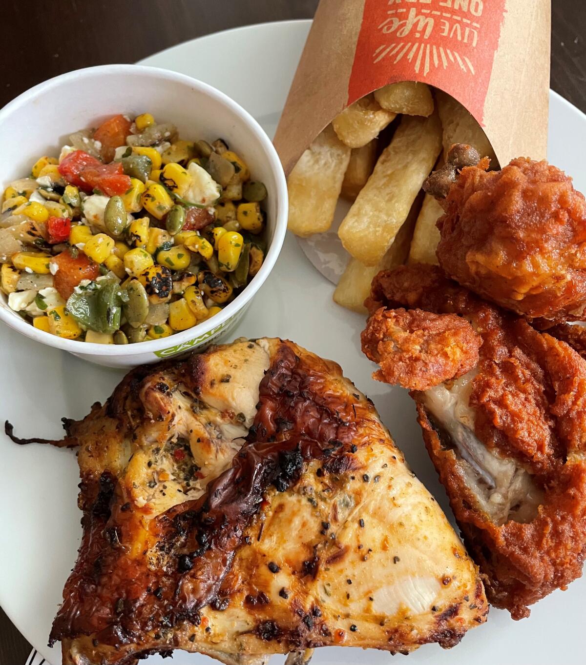 Grilled and fried chicken with sides of corn salad and fried yucca at Pollo Campero.