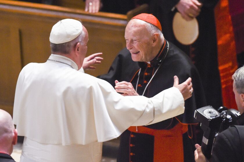 FILE - In this Sept. 23, 2015 file photo, Pope Francis reaches out to hug Cardinal Archbishop emeritus Theodore McCarrick after the Midday Prayer of the Divine with more than 300 U.S. bishops, at the Cathedral of St. Matthew the Apostle in Washington. On Tuesday, Nov. 10, 2020, the Vatican is taking the extraordinary step of publishing its two-year investigation into the disgraced ex-Cardinal McCarrick, who was defrocked in 2019 after the Vatican determined that years of rumors that he was a sexual predator were true. (Jonathan Newton/The Washington Post via AP, File)