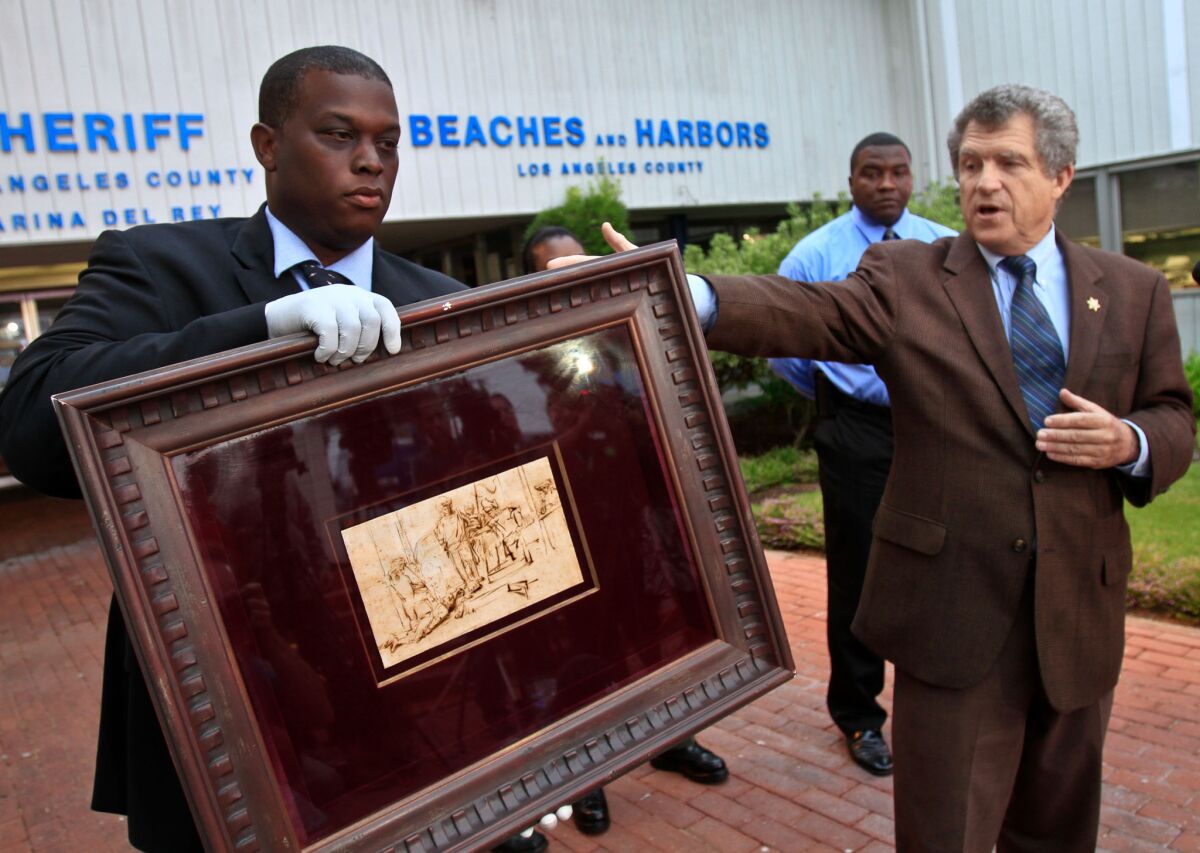Los Angeles County Sheriff's Department spokesman Steve Whitmore, right, at a 2011 news conference where Deputy Clarence Williams shows off a Rembrandt etching that had been recovered after being stolen.