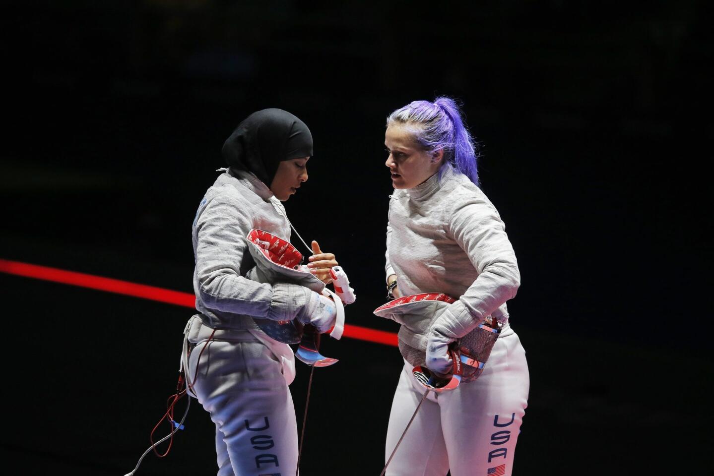 Dagmara Wozniak (R) and Ibtihaj Muhammad (L) of the USA react during the women's Sabre Team bronze medal match against Italy at the Rio 2016 Olympic Games Fencing events at the Carioca Arena 3 in the Olympic Park in Rio de Janeiro, Brazil.