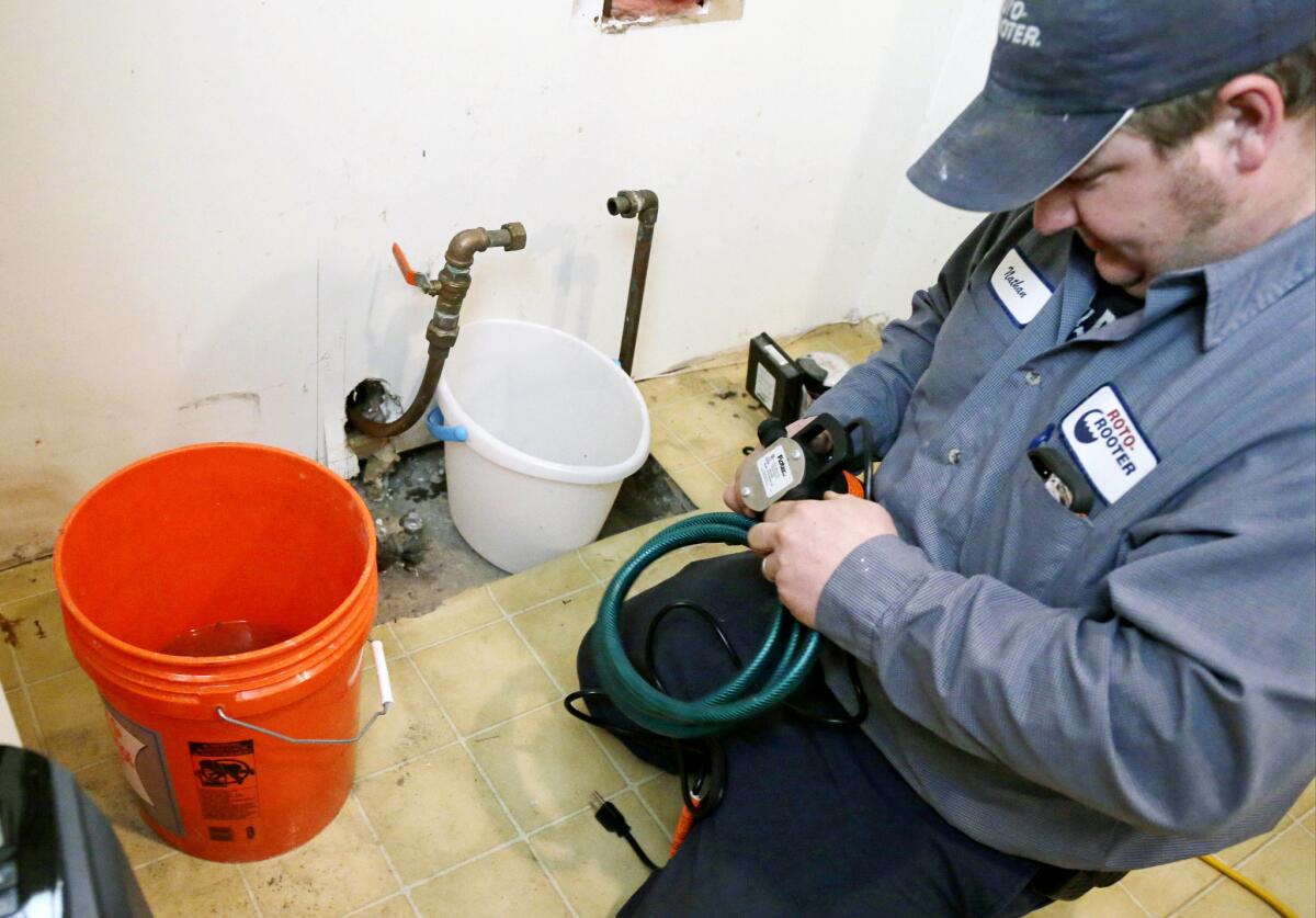Plumber Nate Petersen prepares a pump to shoot water into the incoming city water line, left pipe, that has been frozen Thursday, Jan. 9, 2014, at a south Minneapolis home. Roto Rooter was been "inundated" with calls since the cold snap and regular work has been put on hold because of burst pipes and even frozen sewer lines according to plumbing manager Paul Teale. The deep freeze and storms that gripped much of the country over the past week cost the economy as much as $5 billion, by one estimate. (AP Photo/Jim Mone)