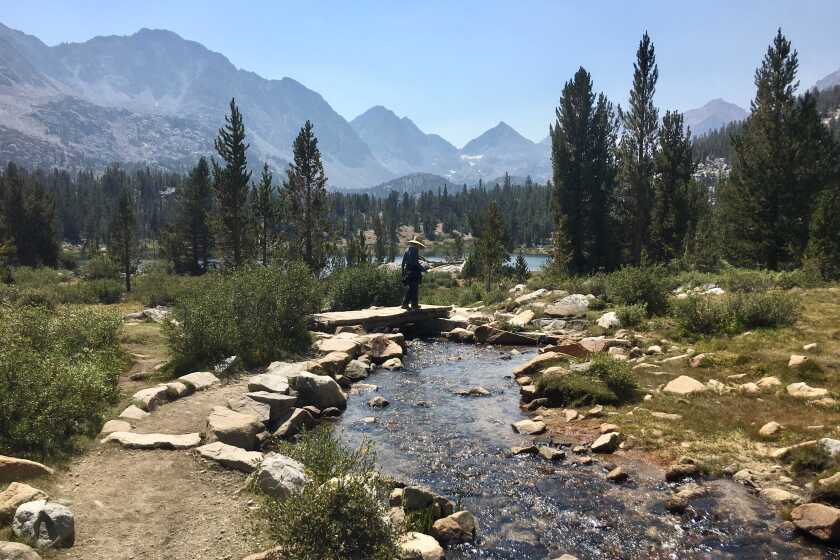 A hiker crosses a stream in the Little Lakes Valley of the Inyo National Forest on August 28, 2020.