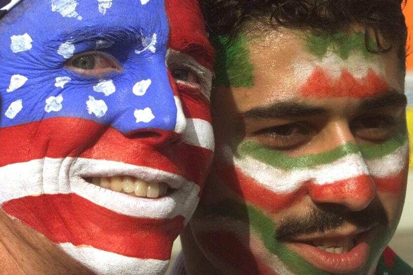 FILE - Mike Moscrop, left, from Orange County, Calif., poses with Amir Sieidoust, an Iranian supporter living in Holland outside the Gerlain Stadium in Lyon, June 21, 1998, before the start of the USA vs Iran World Cup soccer match. Iran defeated the U.S. 2-1 for its first World Cup win, eliminating them after just two games. A rematch between the U.S. and Iran will be played, Tuesday, Nov. 29, 2022. (AP Photo/Jerome Delay)