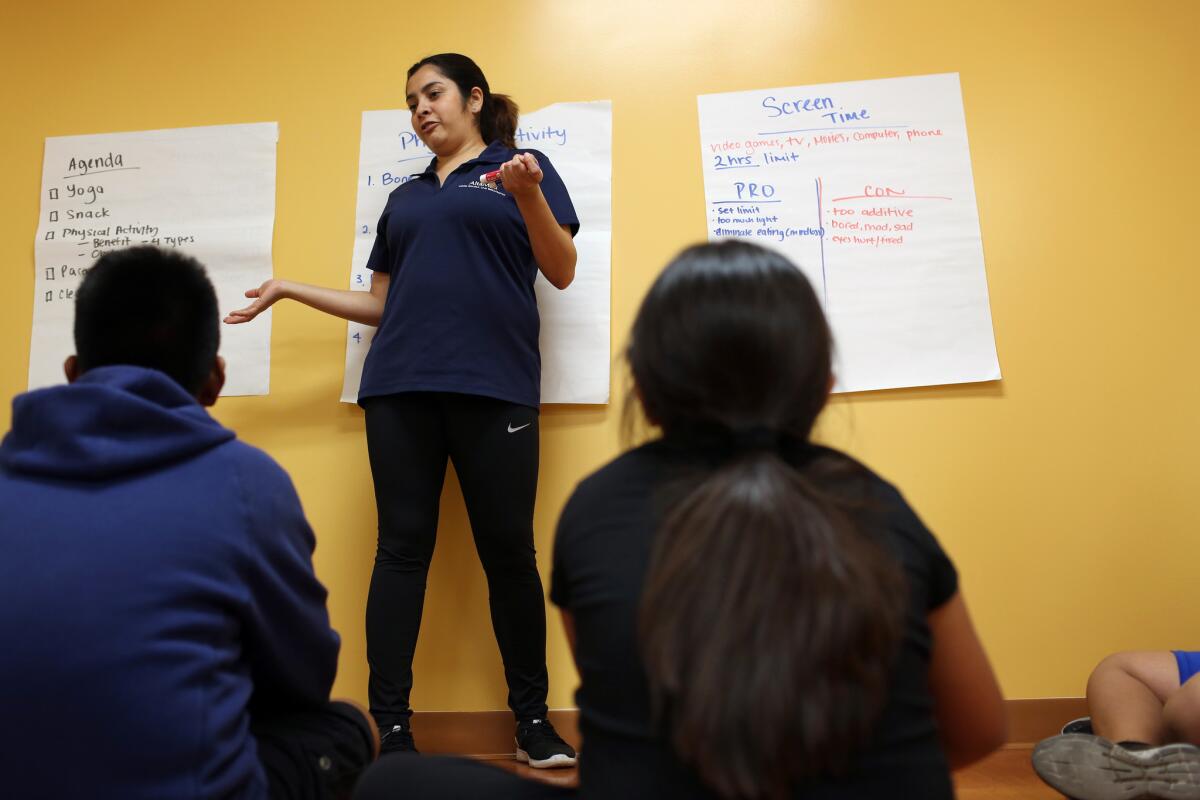 Licetz Montoya, a program coordinator with BodyWorks, talks with kids about possible benefits and detriments of screen time. (Dania Maxwell / Los Angeles Times)