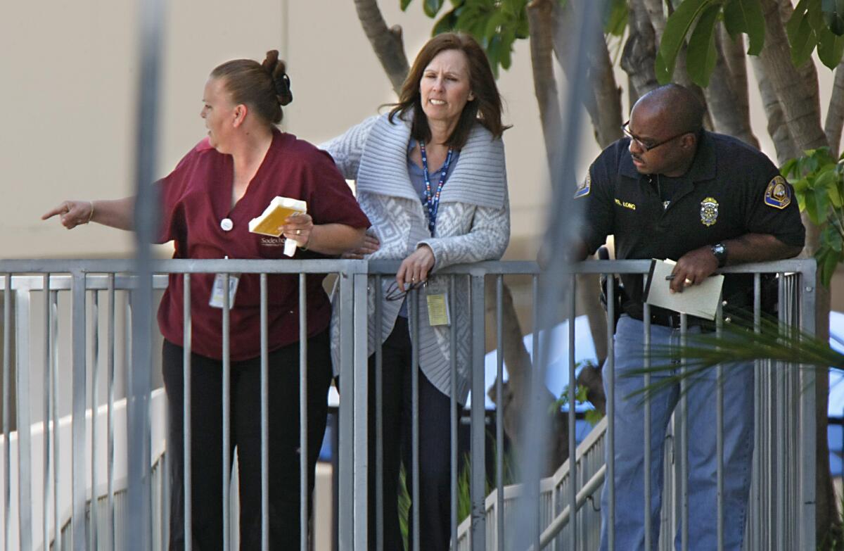 Long Beach Memorial Medical Center employees gather outside the walk-in emergency entry after a 2009 shooting. Hospitals are starting to hold training sessions for employees on what to do if a shooter walks in.