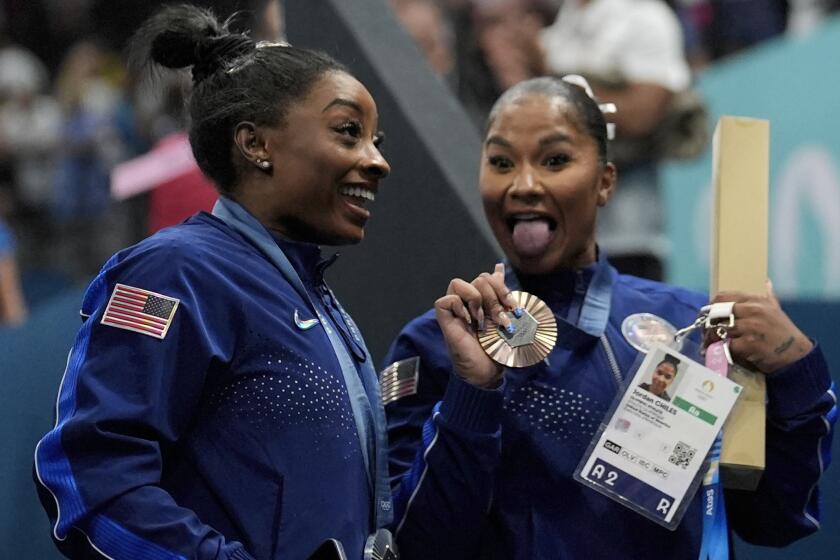 Jordan Chiles, right, joyously shows off her bronze medal next to Simone Biles