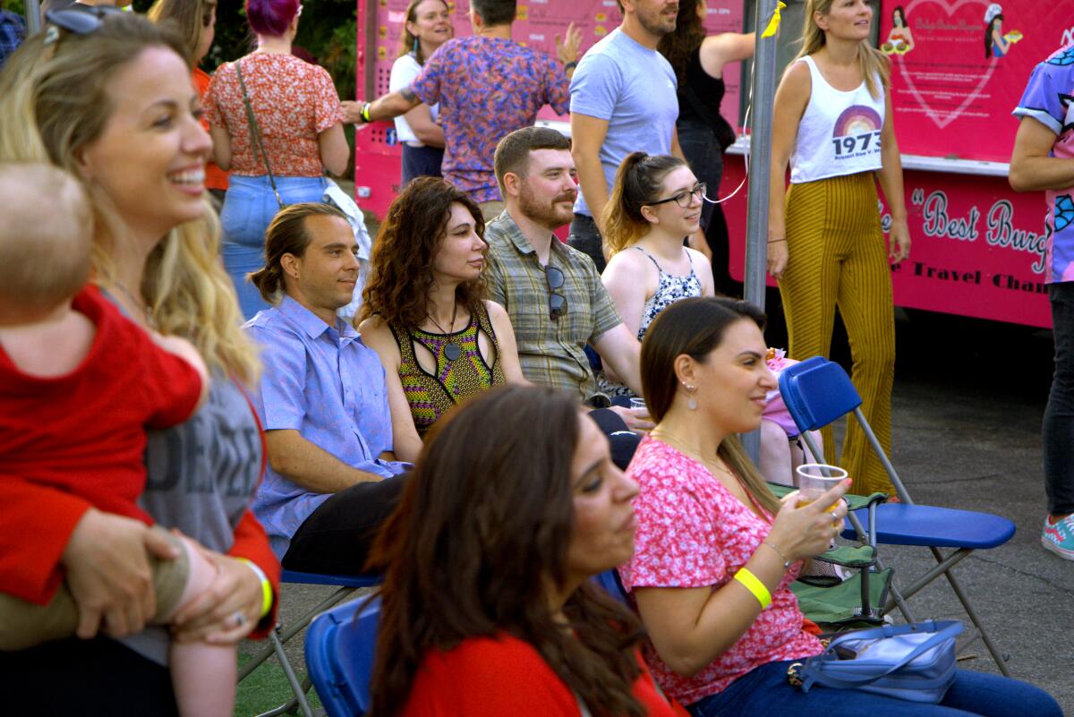 An audience of seated and standing people.