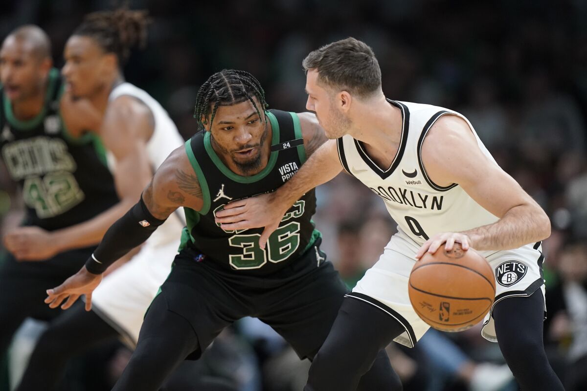 Boston Celtics guard Marcus Smart (36) defends as Brooklyn Nets guard Goran Dragic, of Slovenia, right, looks for an opening in the first half of Game 1 of an NBA basketball first-round Eastern Conference playoff series, Sunday, April 17, 2022, in Boston. The Celtics won 115-114. (AP Photo/Steven Senne)