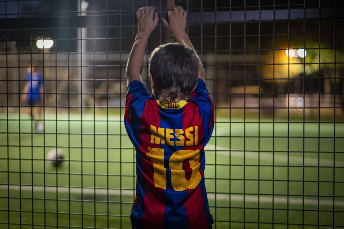 Un niño con una camiseta de Lionel Messi observa un partido de fútbol en Banyoles, España, el miércoles 2 de septiembre de 2020. (AP Foto/Emilio Morenatti)