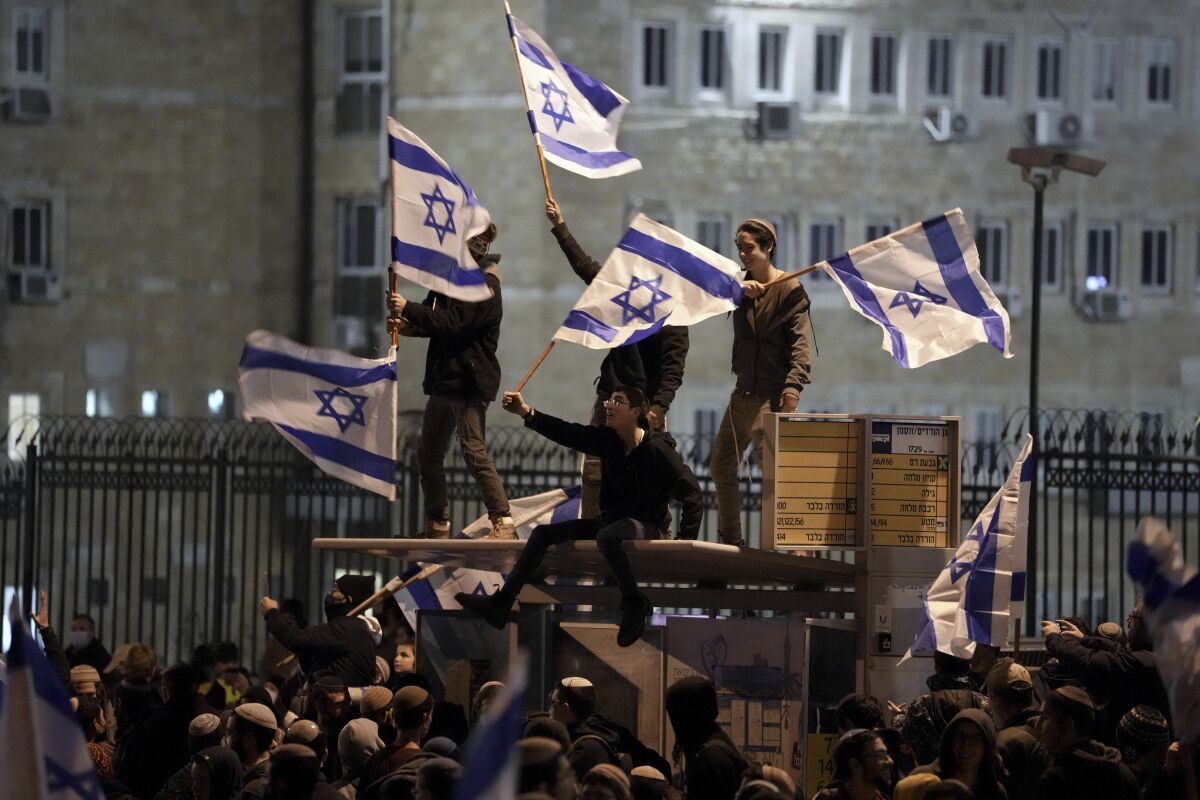 Israeli nationalists weave flags during a protest outside the parliament building in Jerusalem.