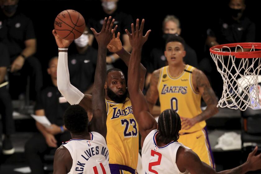 Lakers forward LeBron James is defended by the Clippers' JaMychal Green (4) and Kawhi Leonard (2) during the fourth quarter.