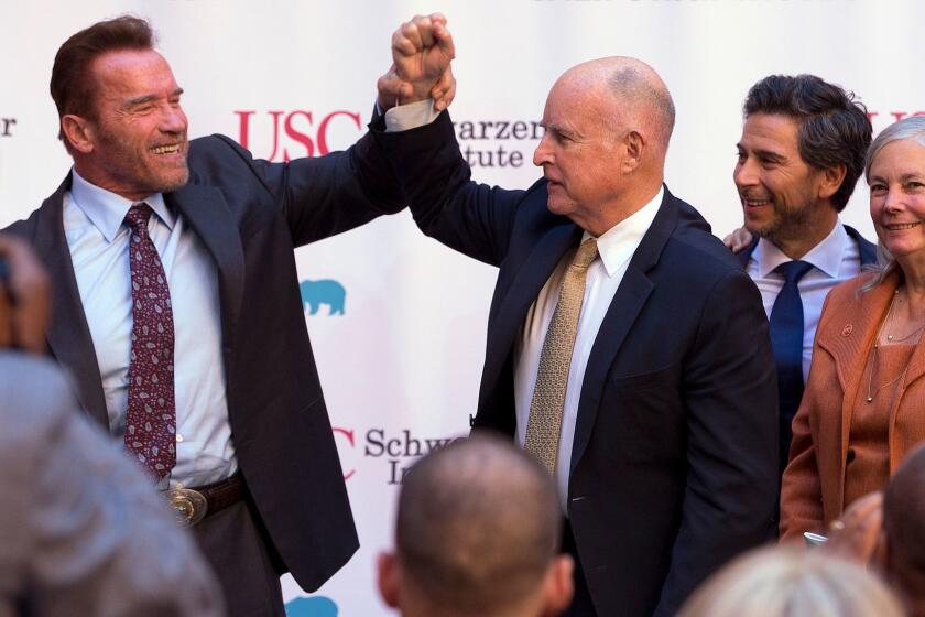 Former Gov. Arnold Schwarzenegger, left, shakes hands with Gov. Jerry Brown during a celebration of the 10th Anniversary of Schwarzenegger signing California's landmark global warming bill, AB32, Wednesday, Oct. 5, 2016, in Sacramento, Calif. Looking on are former Assembly Speaker Fabian Nunez, D-Los Angeles, second from right and Sen. Fran Pavley, D-Agoura Hills, the author of AB32. (AP Photo/Rich Pedroncelli)