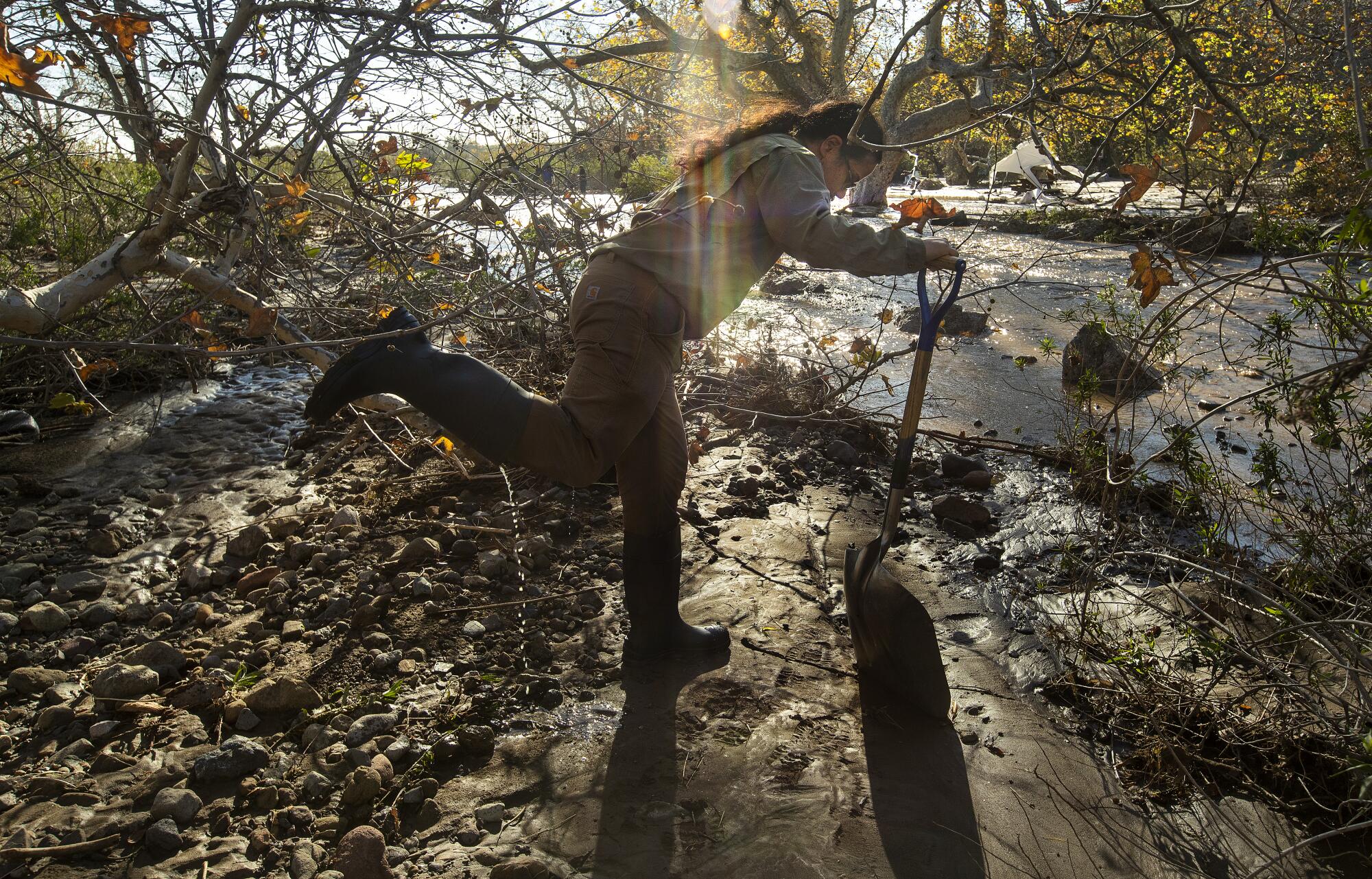 John Ota, an environmental scientist with the California State Parks, removes water from his boot