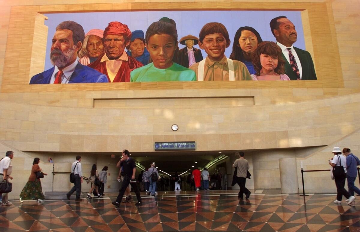 FILE - In this Aug. 30, 2000, file photo, commuters walk into a tunnel at Los Angeles's Amtrack-Metrolink Union Station under the mural "City of Dreams/River of History" by artist Richard Wyatt, showing the diversity of California's population. Many U.S. companies have rushed to appoint Black members to their board of directors since racial justice protests swept the country last year. But in the two preceding years, progress on increasing racial diversity on boards stagnated, a new study revealed Tuesday, June 8, 2021. California Gov. Gavin Newsom signed a new law last year giving companies until the end of 2021 to have at least one board member from an underrepresented ethnic communities, or who identify as LBGT. (AP Photo/Damian Dovarganes, File)