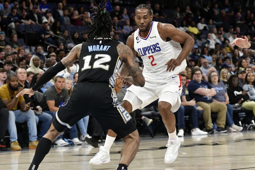 The Clippers' Kawhi Leonard handles the ball against the Grizzlies' Ja Morant on March 31, 2023.