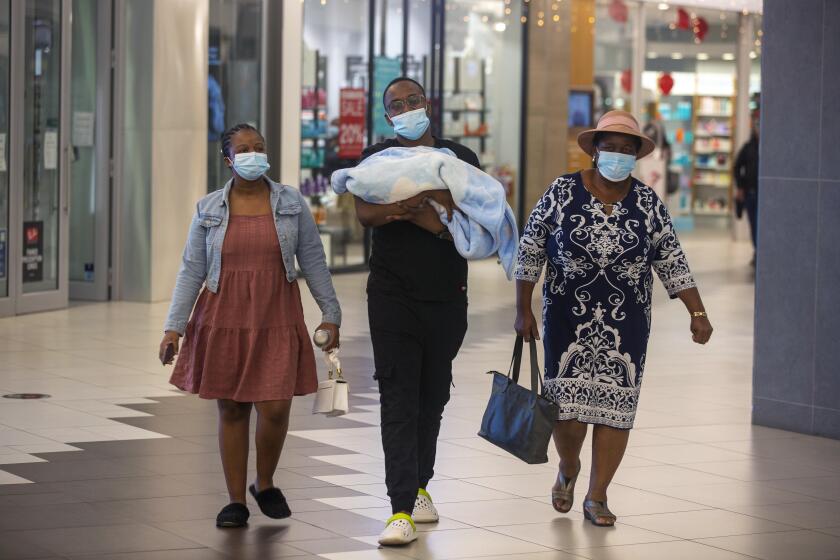 People with masks walik, at a shopping mall, in Johannesburg, South Africa, Friday Nov. 26, 2021. Advisers to the World Health Organization are holding a special session Friday to flesh out information about a worrying new variant of the coronavirus that has emerged in South Africa, though its impact on COVID-19 vaccines may not be known for weeks. (AP Photo/Denis Farrell)