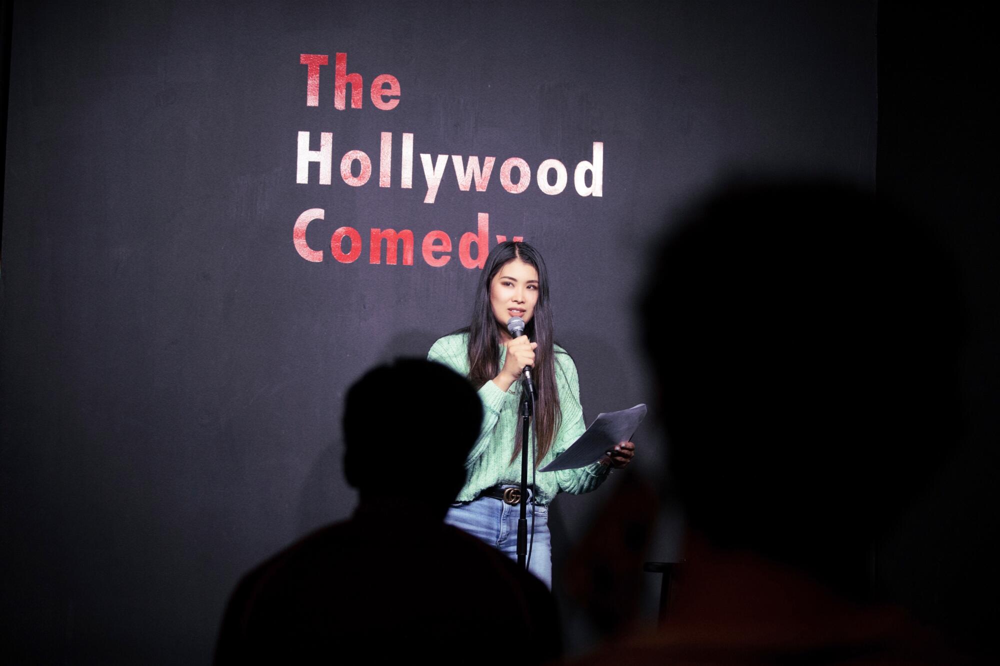 A woman at a mic onstage 