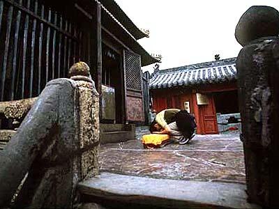 A Taoist worshiper kneels before Golden Hall on Tianzhu Peak.