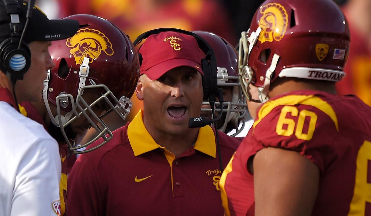 USC interim head coach Clay Helton talks to his team during the first half against Utah on Oct. 24.