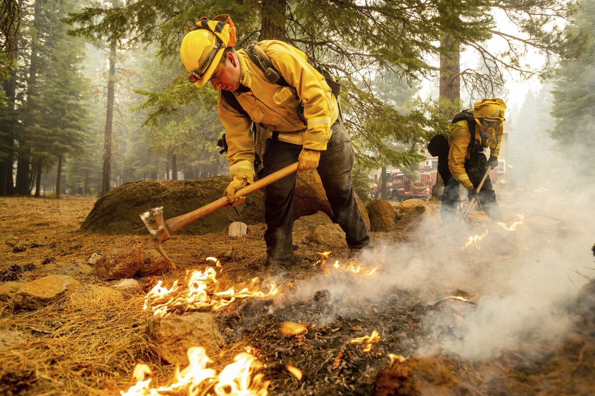 Firefighters extinguish hot spots while protecting Lake Almanor West homes from the Dixie fire 
