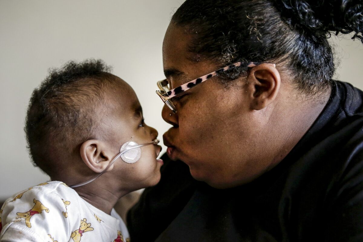 Curtis Means kisses his mother, Michelle Butler at their home in Eutaw, Ala., on Wednesday, March 23, 2022. Butler was just over halfway through her pregnancy when her water broke and contractions wracked her body. She couldn't escape a terrifying truth: Her twins were coming much too soon. (AP Photo/Butch Dill)