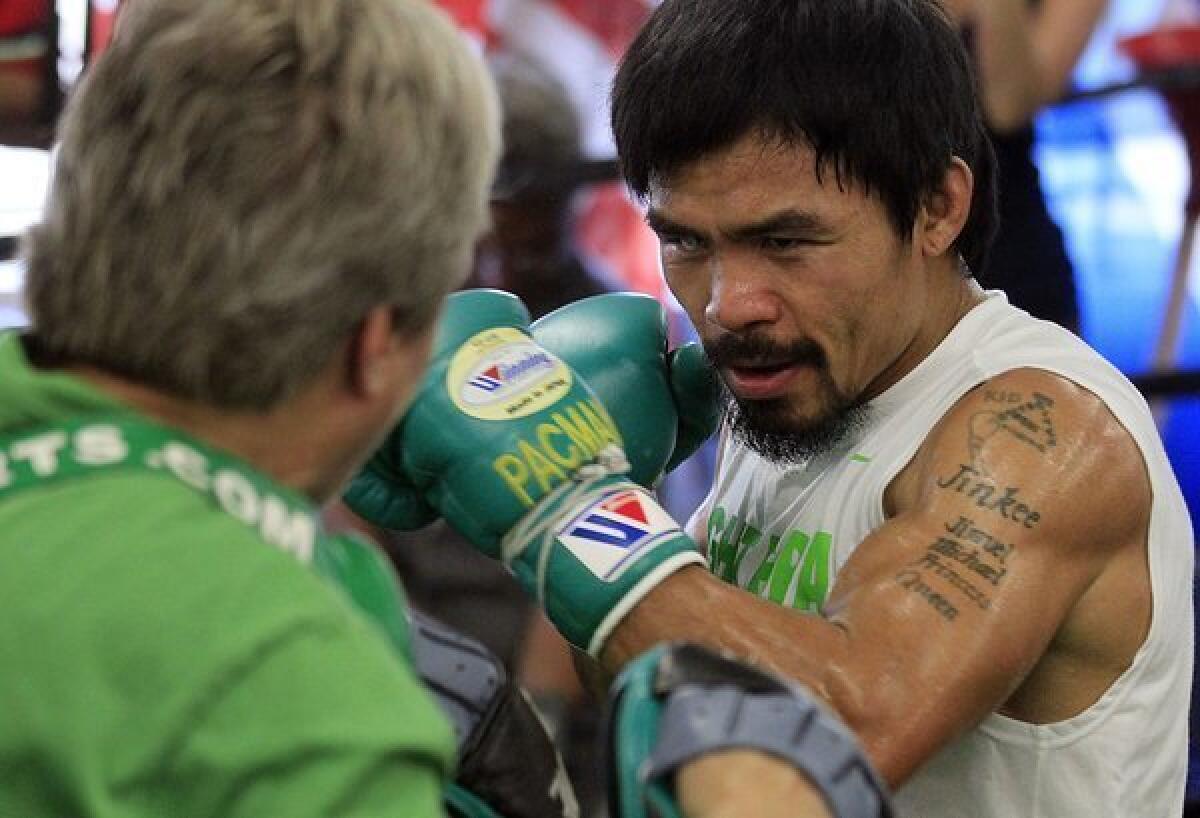 Boxing champion Manny Pacquiao works out with trainer Freddie Roach at the Wild Card Boxing Club in Hollywood earlier this year.
