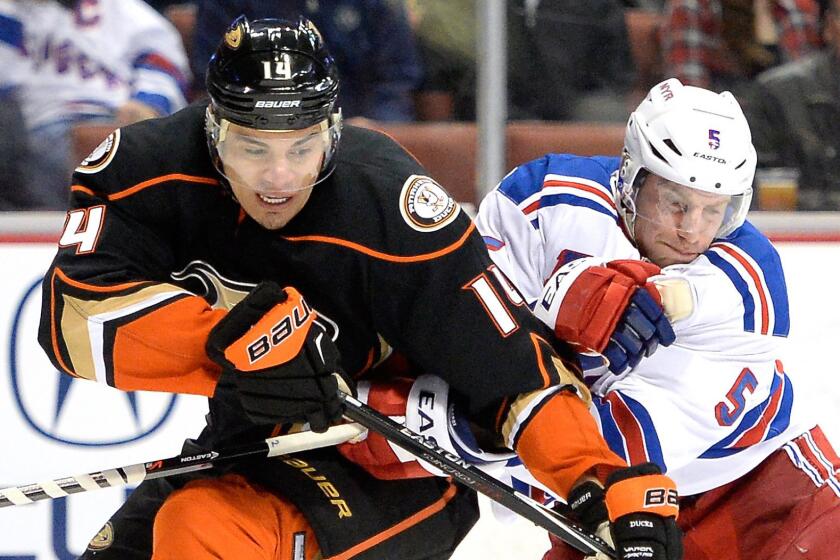 New York Rangers defenseman Dan Girardi, right, breaks up a pass to Ducks forward Rene Bourque, left, during a game at Honda Center on Jan. 7.