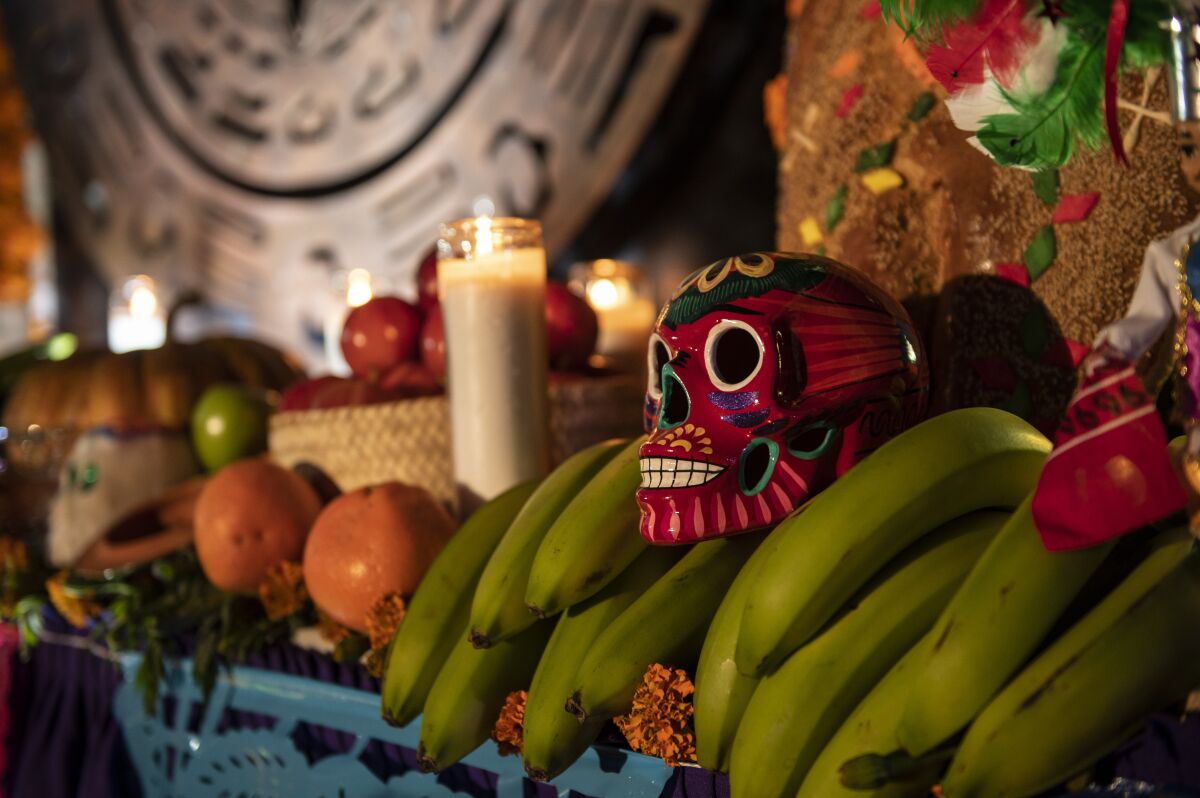 Fruit, skull and candle on a Día de Muertos ofrenda