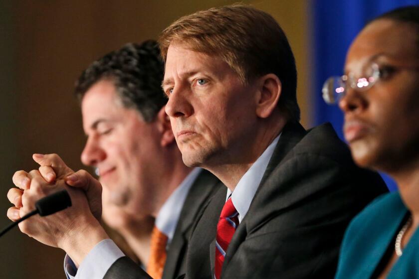 FILE - In this Thursday, March 26, 2015, file photo, Consumer Financial Protection Bureau Director Richard Cordray, center, listens to comments during a panel discussion in Richmond, Va. On Tuesday, Oct. 11, 2016, a federal appeals court ruled that the way the CFPB is organized violates the Constitutionâs separation of powers by limiting the presidentâs ability to remove the director who heads the agency. Cordray, a Democrat and former Ohio attorney general, has run the agency since it began operating in July 2011. (AP Photo/Steve Helber, File)
