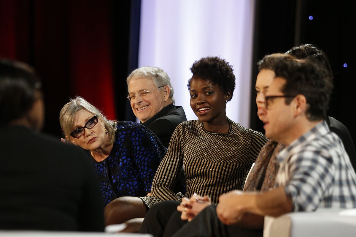 Carrie Fisher, in glasses, is all ears as director J.J. Abrams, right, speaks out while Lawrence Kasdan, from left, and Lupita Nyong’o enjoy the proceedings.