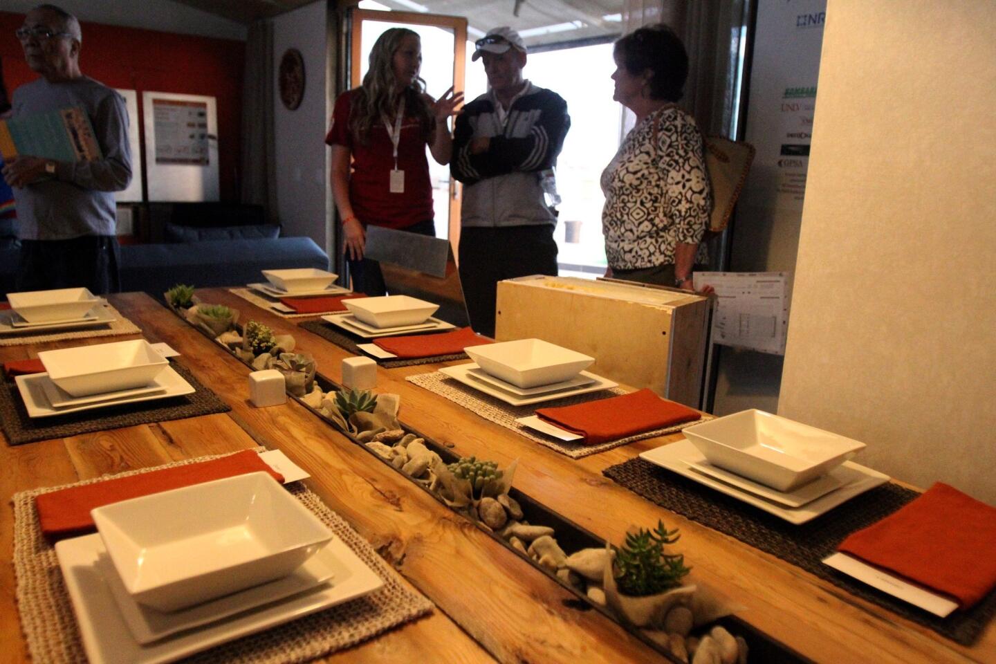 A tour during the public opening of the UNLV house pauses by the table students designed with a central trough for succulents and built using scrap materials. Final team score: 947.572. Full article on UNLV house