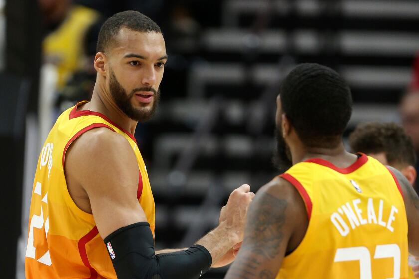 Jazz center Rudy Gobert talks to teammate Royce O'Neale (23) during a game earlier this season.