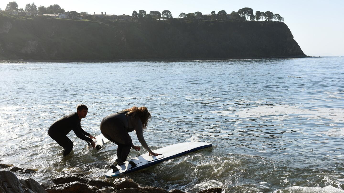 Brian Jones of Los Angeles and Mimi Miller of the South Bay head out to surf.