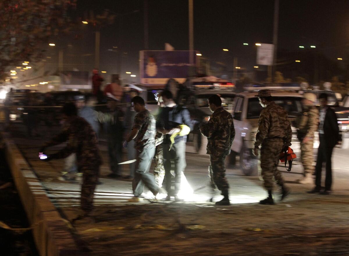 Afghan security and intelligence official inspect the site of a suicide attack in Kabul. A bomber riding a bicycle was killed when his explosive went off prematurely, wounding a passerby, police officials said.