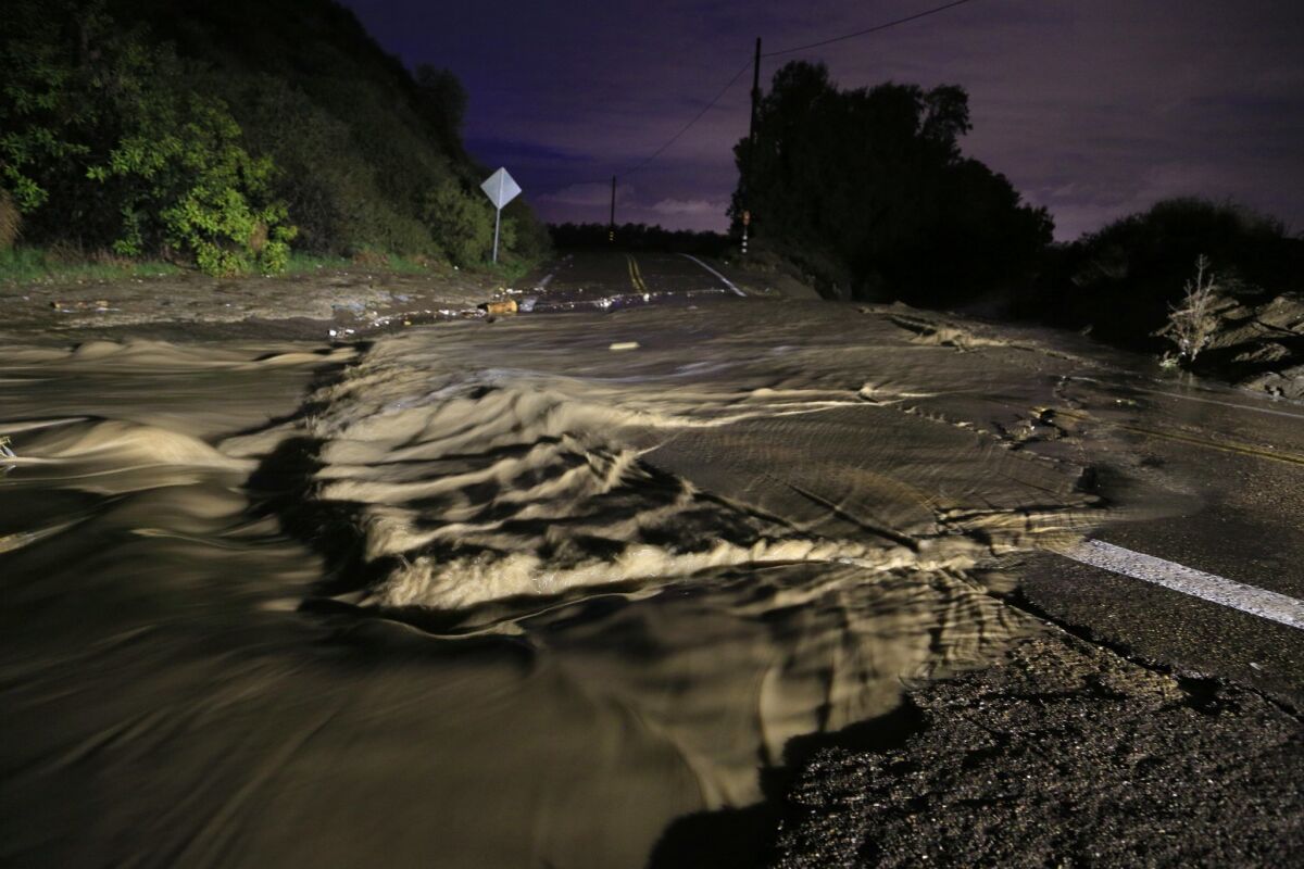 Rain water floods Monument Road near the Tijuana River Valley. — Misael Virgen / San Diego Union-Tribune