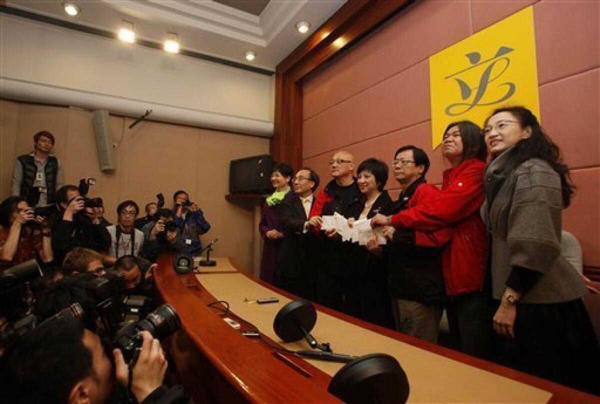 Five Hong Kong legislators Tanya Chan, right, Leung Kwok-hung, second right, Wong Yuk-man, third right, Albert Chan, third left, Alan Leong, second left, present the resignation letter to Pauline Ng, center, Secretary General inside the Legislative Council in Hong Kong Tuesday, Jan. 26, 2010. The five legislators have resigned to pressure China for democracy in this semiautonomous former British colony. The lawmakers from the League of Social Democrats and Civic Party signed and held up their resignation letters for photographers Tuesday, then handed them to the secretary of Hong Kong's Legislative Council. (AP Photo/Kin Cheung)
