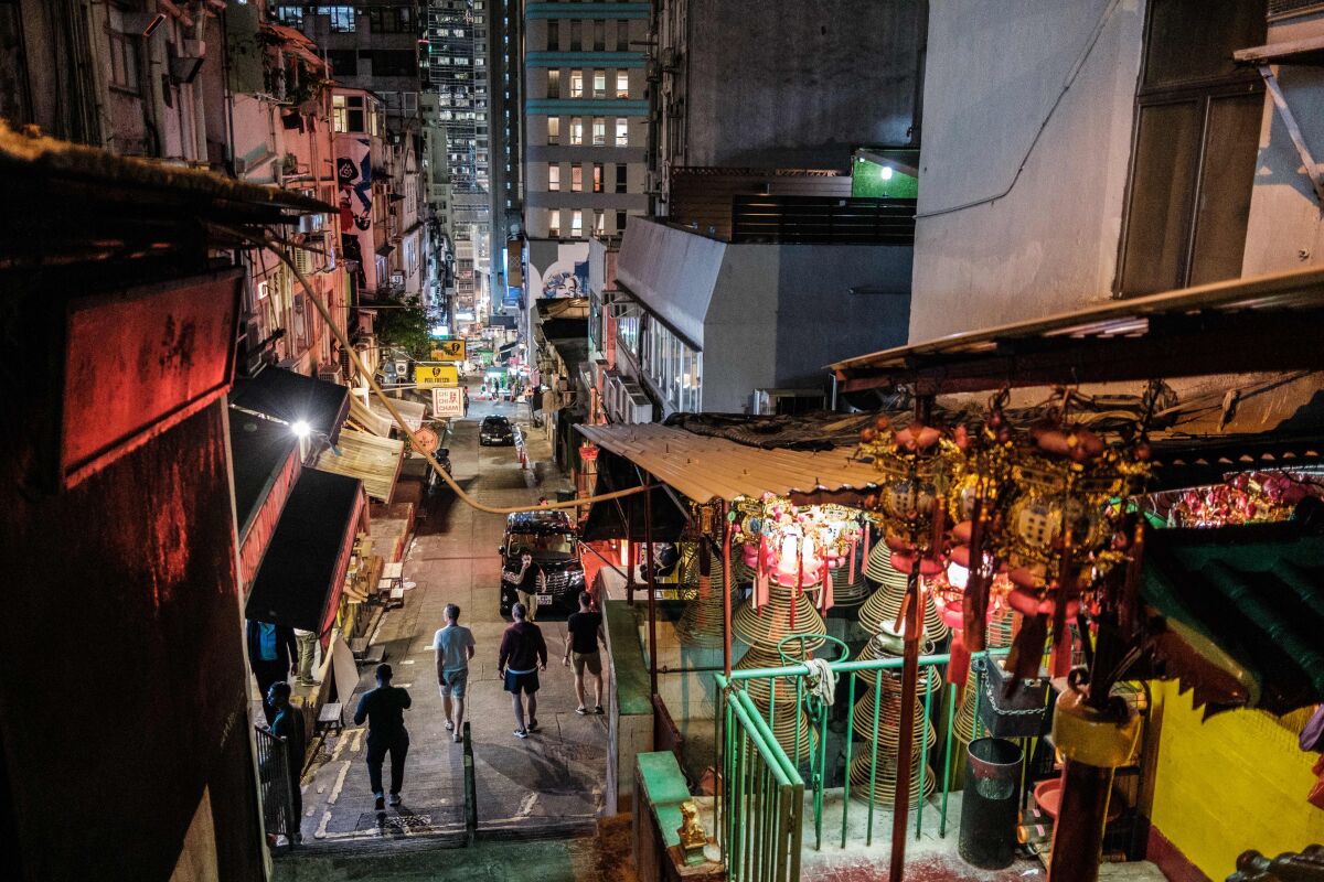 Pedestrians walk on the usually busy Peel Street, popular for its restaurants and bars, in Hong Kong. The city's chief executive announced plans to temporarily ban the sale of alcohol in bars and restaurants as a measure to help stop the spread of the coronavirus.