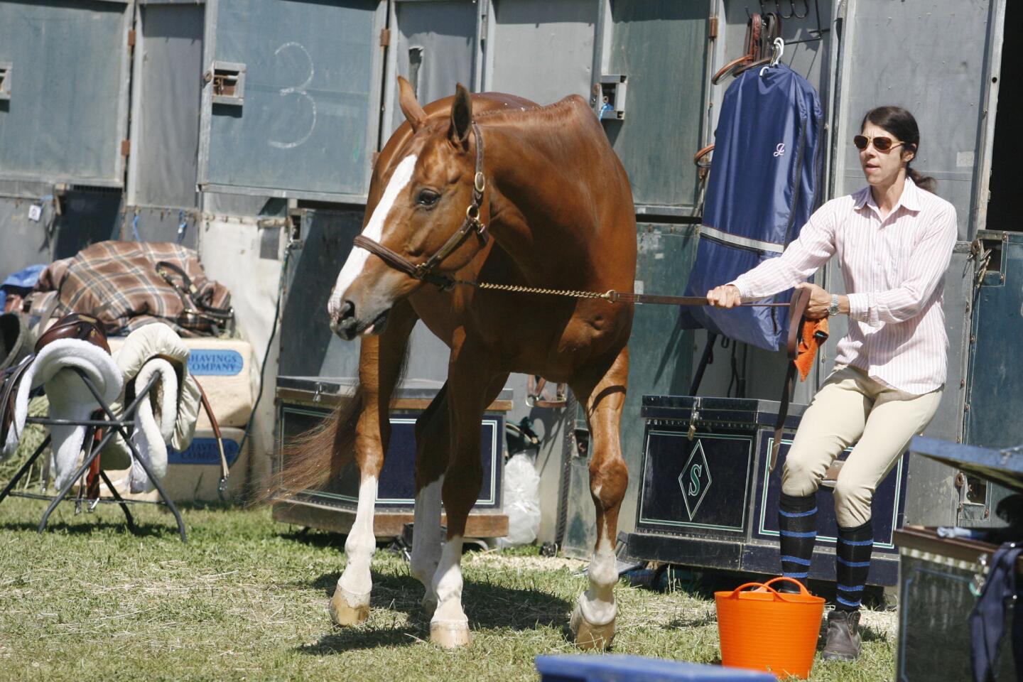 Melissa Bulick, right, takes Versace out of the barn before showering Versace during Flintridge La Cañada Guild's annual horse show on Saturday, April 28, 2012.