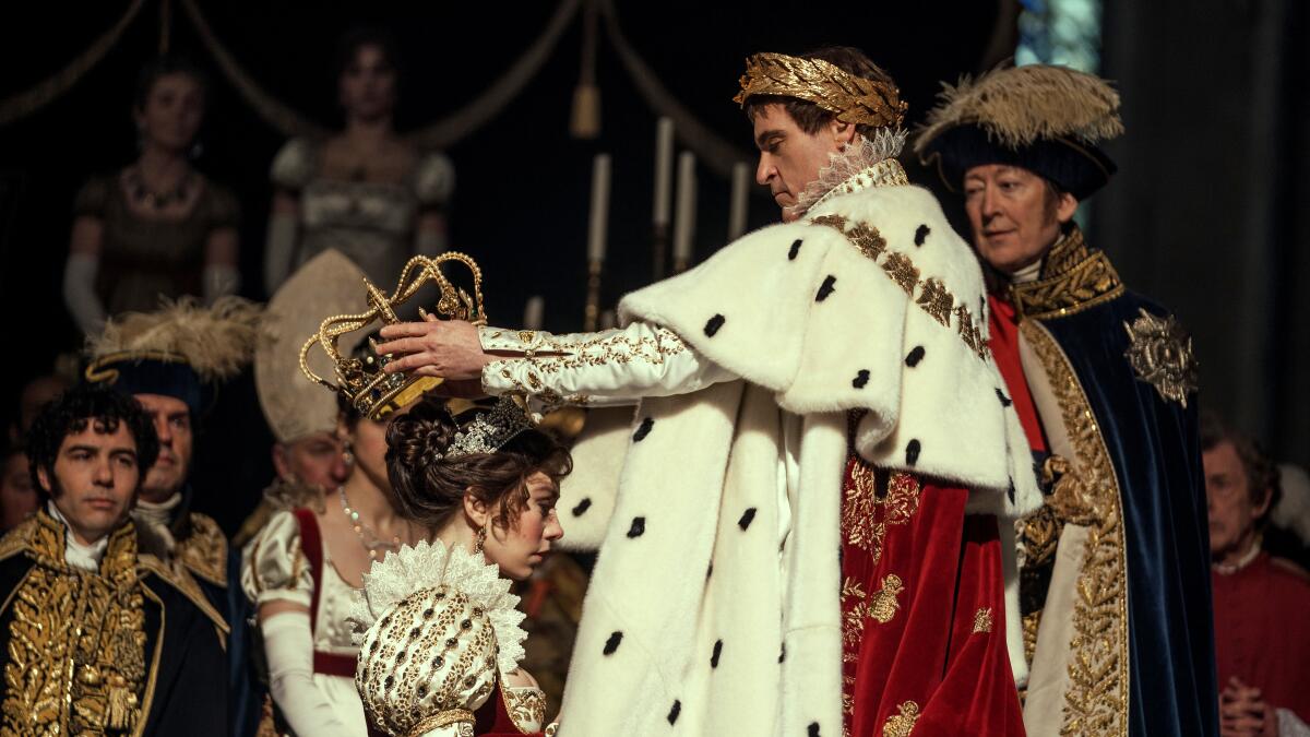 Napoleón, vestido con finas túnicas, corona a Josefina arrodillada en 