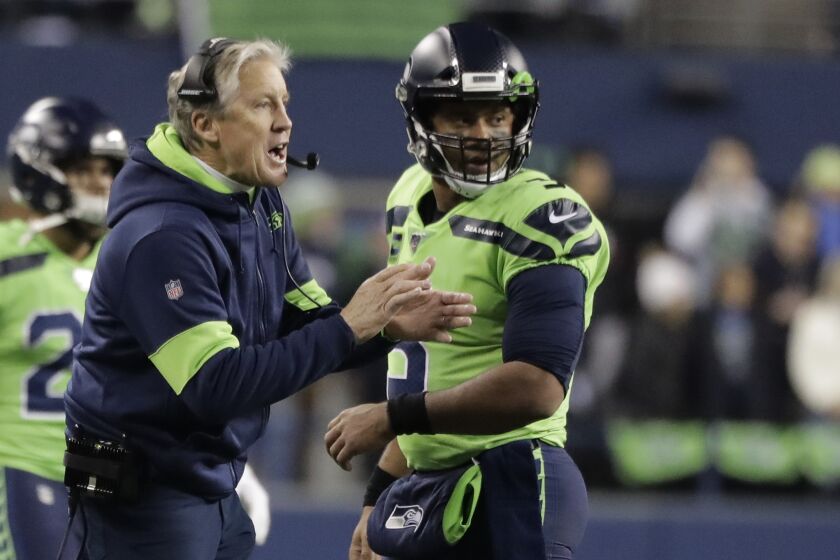Seattle Seahawks head coach Pete Carroll, left, talks with quarterback Russell Wilson during the first half of an NFL football game against the Minnesota Vikings, Monday, Dec. 2, 2019, in Seattle. (AP Photo/Ted S. Warren)