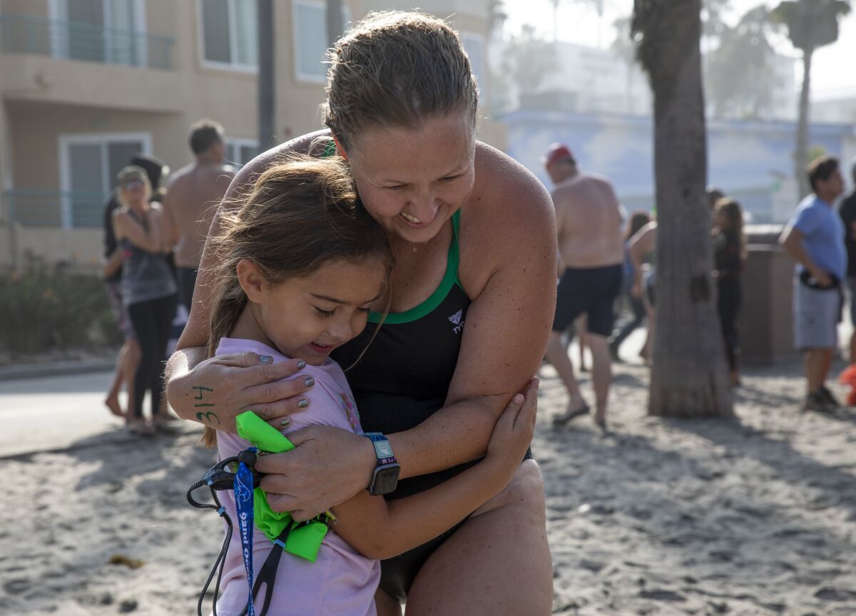 Shannon Parker, 36, hugs her daughter Olivia, 6, after finishing the 2021 Labor Day Pier Swim in Oceanside.