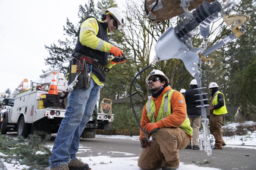 Workers from PG&E work on restoring power to the area after a storm on Tuesday, Jan. 16, 2024, in Lake Oswego, Ore. (AP Photo/Jenny Kane)