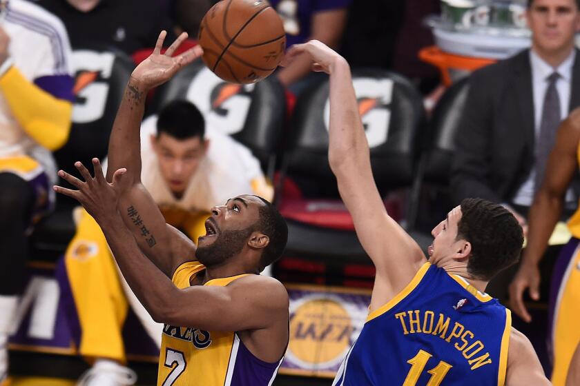 Wayne Ellington has a shot blocked by Klay Thompson of Golden State during the first quarter of the Lakers' 115-105 win Tuesday at Staples Center.