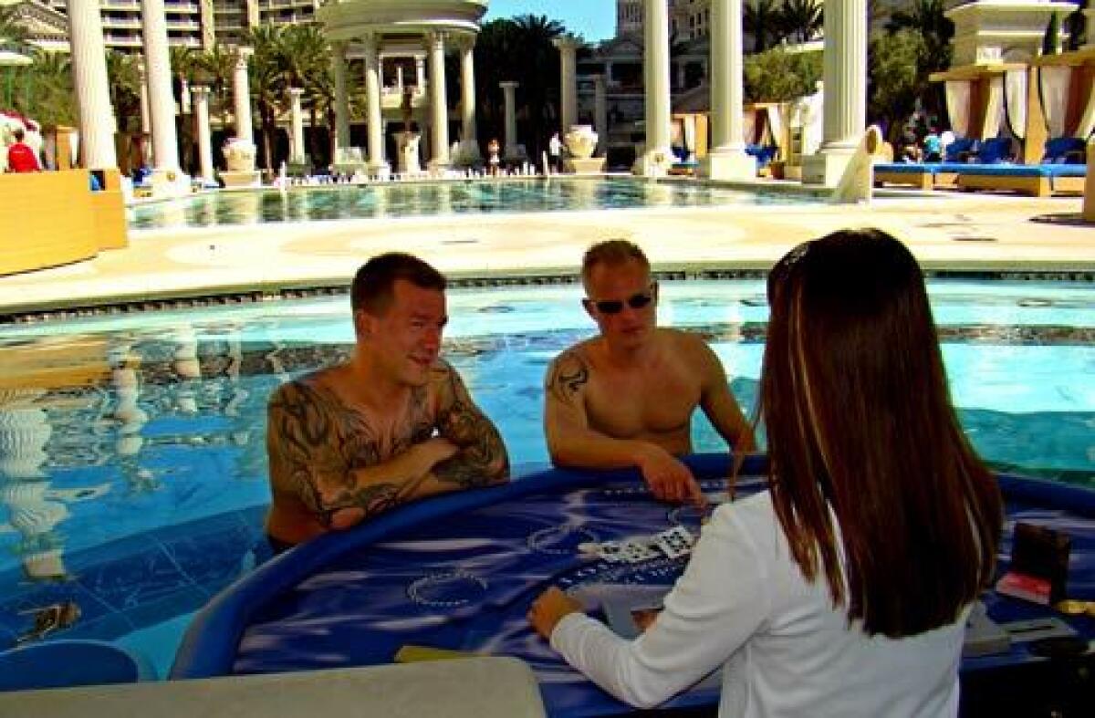 Benjamin Jensen, left, and Peter Andersen of Denmark get a blackjack lesson in the Caesars Palace pool.