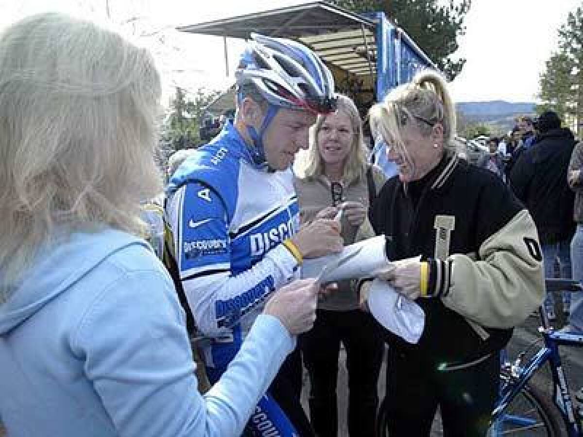 Lance Armstrong is surrounded by autograph seekers before heading out on a 100-mile training ride with his teammates around Solvang.
